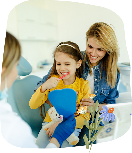 Young girl at a dental appointment sitting in her mother's lap