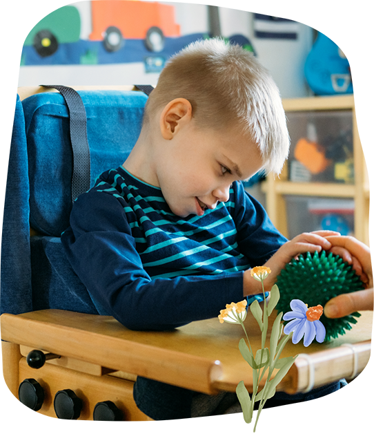 Young boy in a wheelchair holding a spiked ball