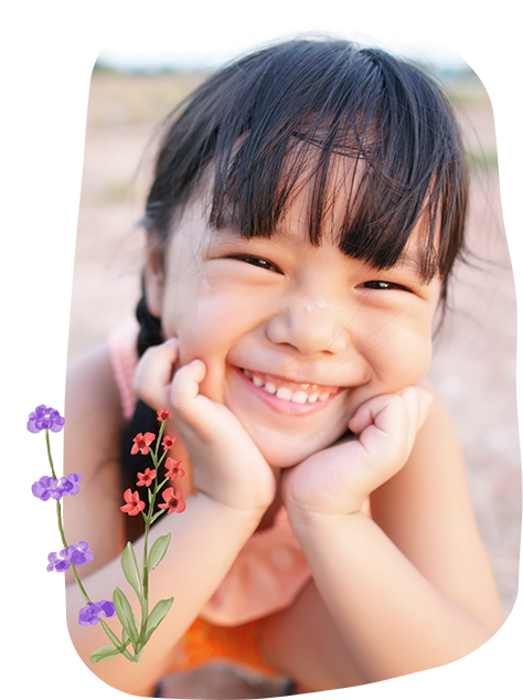 Young girl grinning and resting her chin in her hands