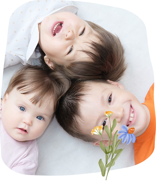 Three kids laying down in a circle with their heads in the middle