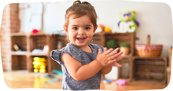 Toddler smiling and clapping their hands