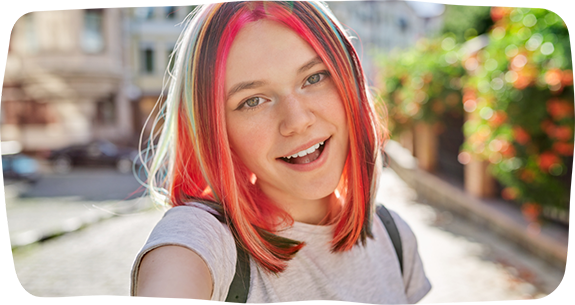 Teenage girl with bright red hair smiling